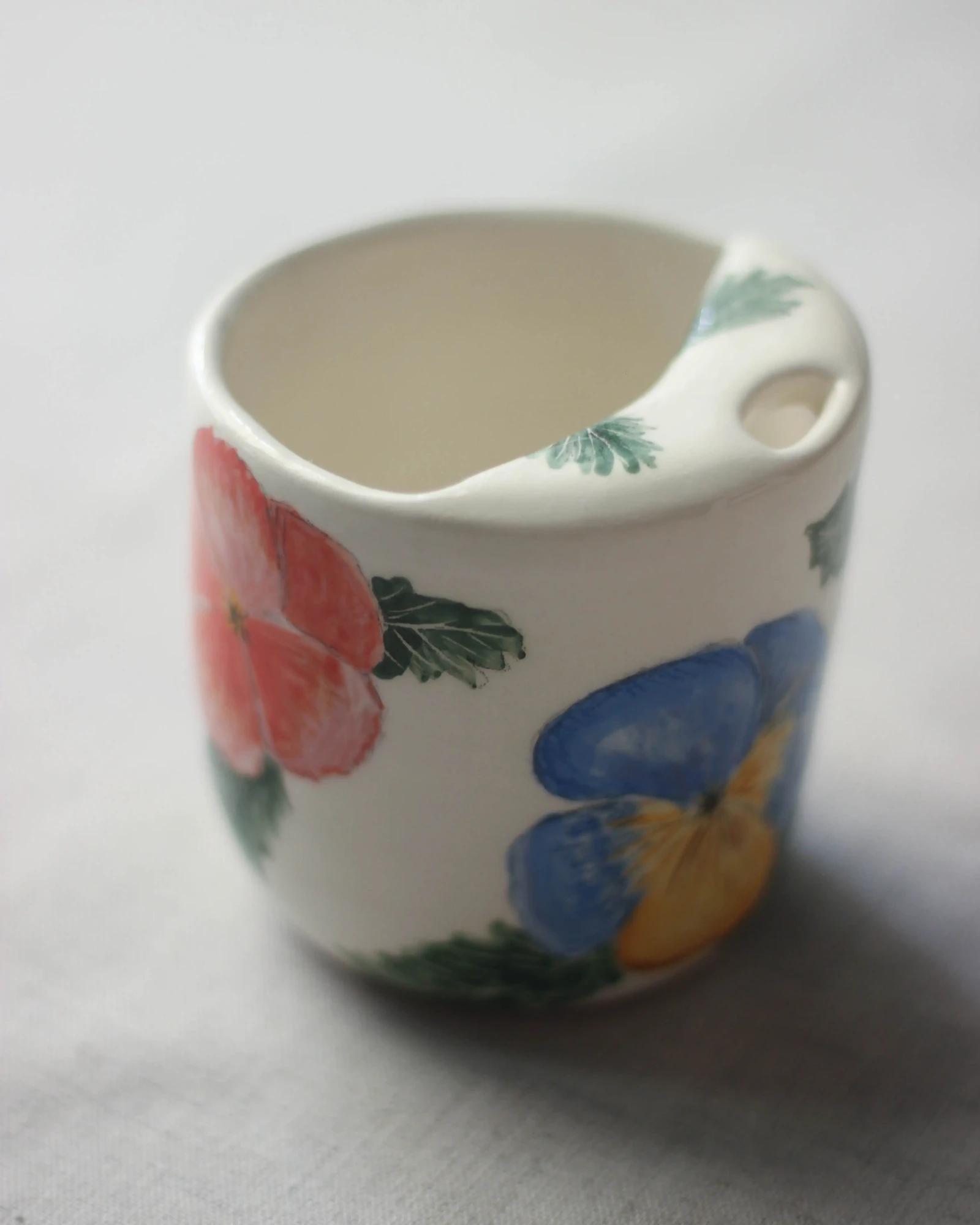 To-go cup with pansies by Dirt Person Ceramics